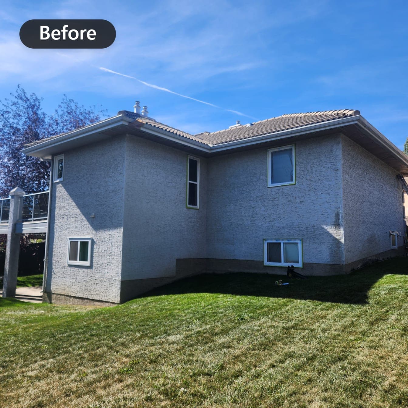 House exterior with faded grey stucco before painting