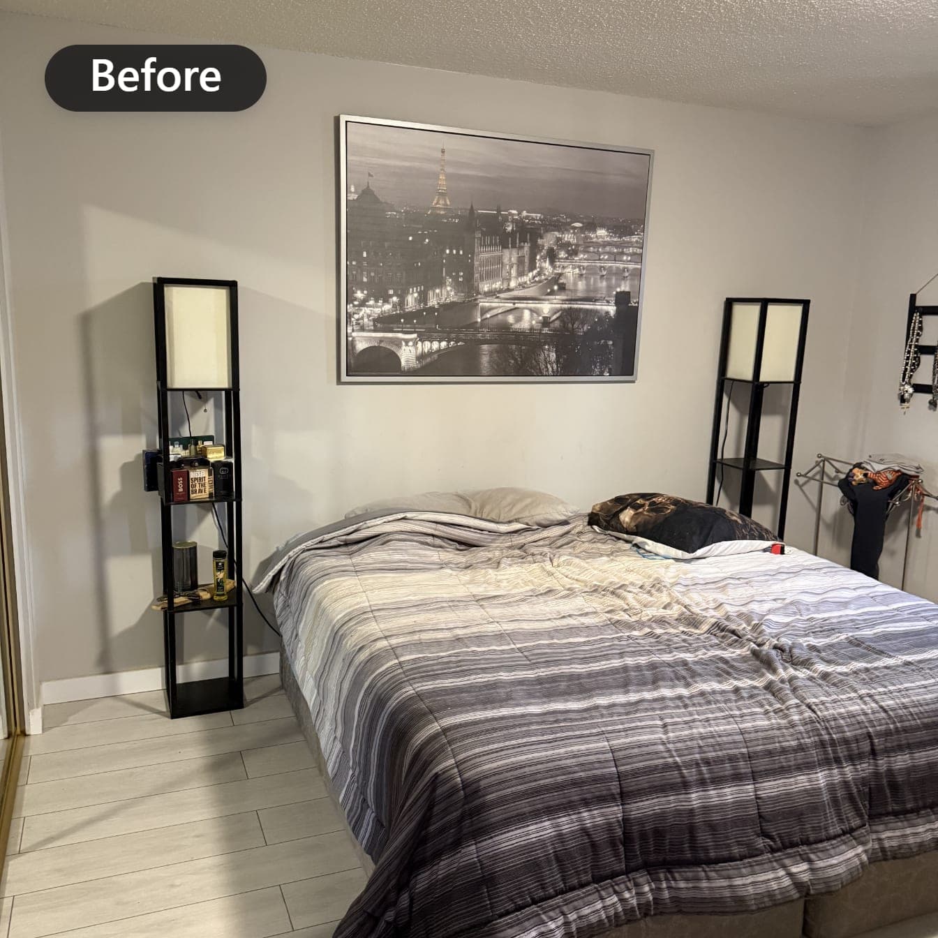 Bedroom with light neutral walls before painting, bed, framed print and floor lamps in place